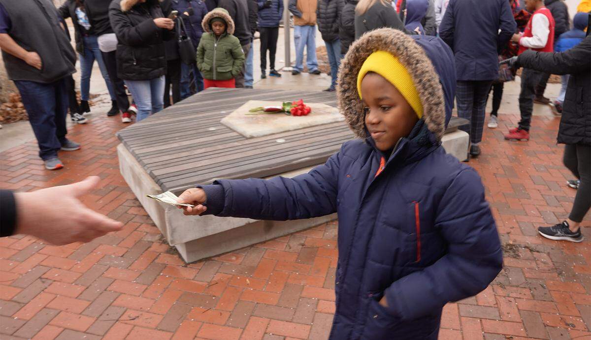 Marcus Jones walked up to League 42 founder and executive director Bob Lutz during a gathering amid frigid temperatures Saturday morning at McAdams Park and handed him $2 from his allowance.