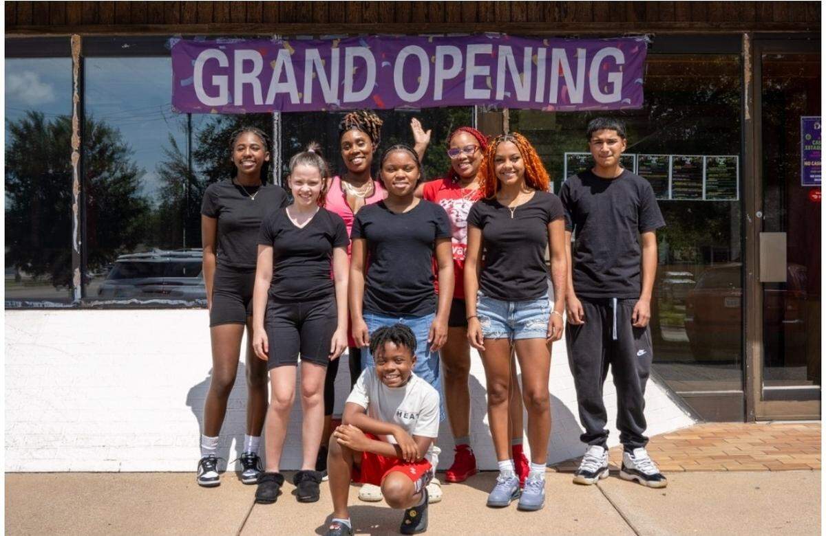 A Different Type of Flava owners Kara Korean, second from left, back row, and her Atlantiz Pete, third from left, back row, pose with some of their young employees in front of the new restaurant on 13th Street. They are, left to right in the back row, Mariyah, left, and Johnny, right, both 15; left to right in the middle row, Shi-Ann, age 14, Jha’Mya, age 14 and Ayonna, age 18. Khalil, age 8, poses with the crew in front.