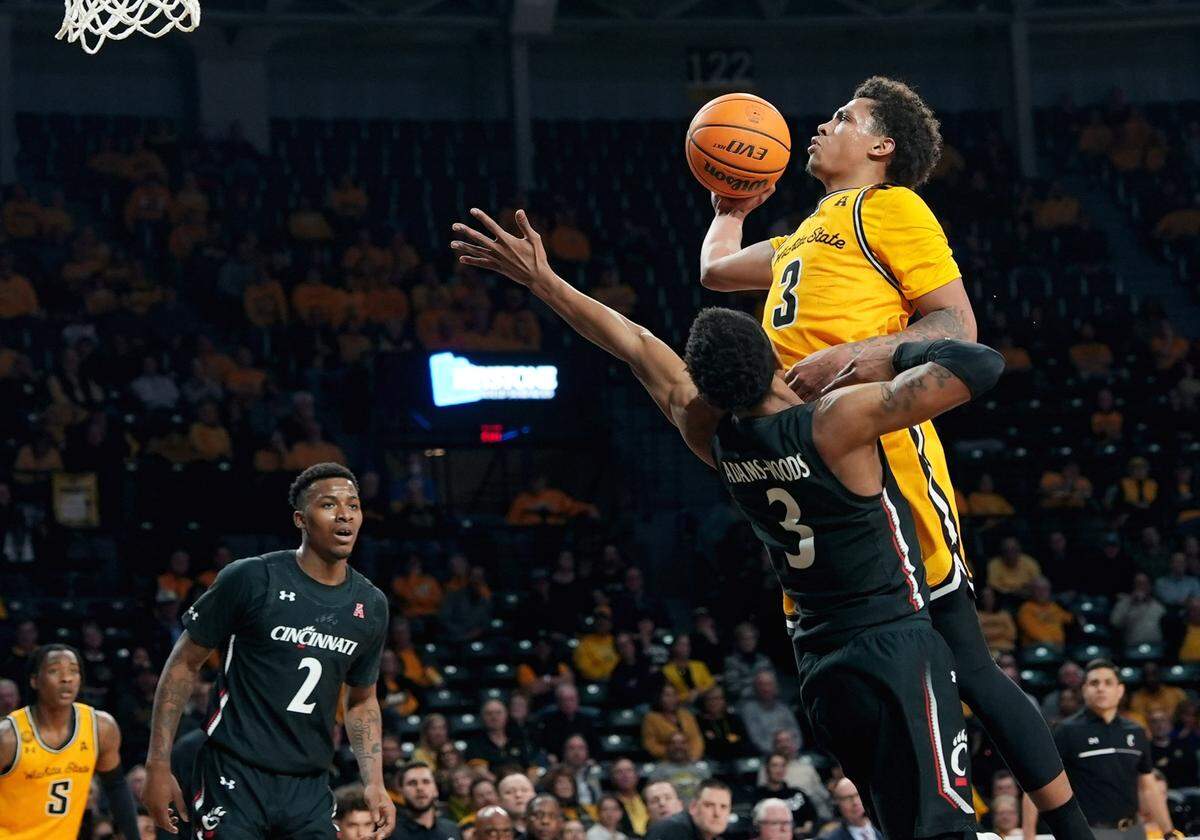 Wichita State’s Craig Porter Jr. shoots over Cincinnati’s Mika Adams-Woods during the first half of their game at Charles Koch Arena.