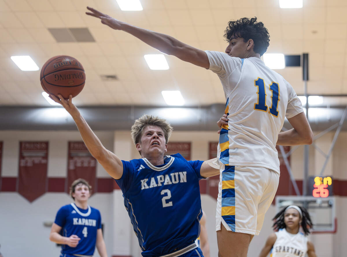 Kapaun’s Jude Porter tries to get a shot past Collegiate’s Shad Issa during the second half of their game at Friends University on Monday night.
