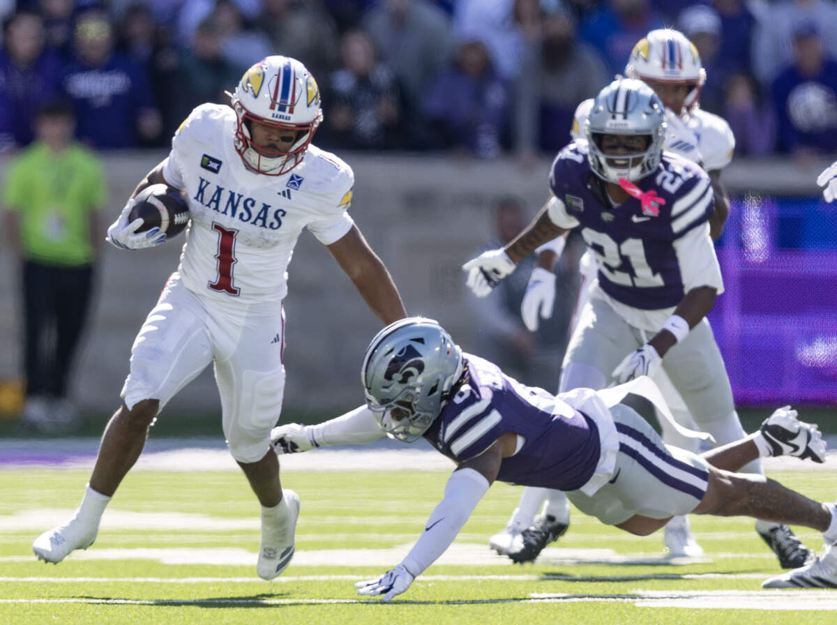 Kansas running back Dylan Edwards tries to evade the Kansas defense during the second half of their game in Manhattan on Saturday.