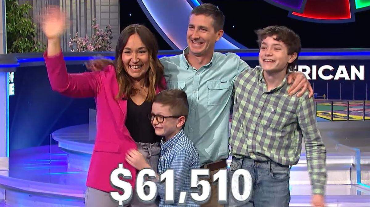 Kiley Klug, left, of Odin, Kansas, waves and smiles with her husband and two of their three sons after she won on “Wheel of Fortune.” The episode aired Friday night.