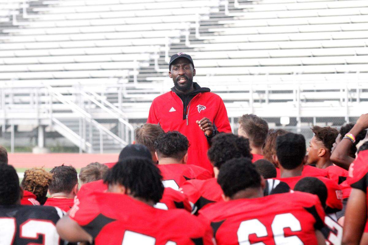 First year coach Dominick Dingle talks with his Wichita Heights football team after a fall practice.