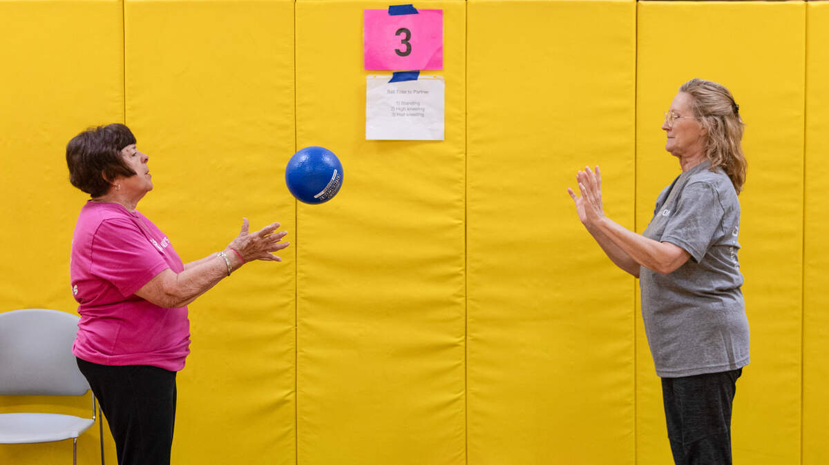 Marilyn Alcala, left, and Susan Kellogg toss a ball back and forth to one another during a Club Parkinson’s exercise class at Wichita State University’s Heskett Center.