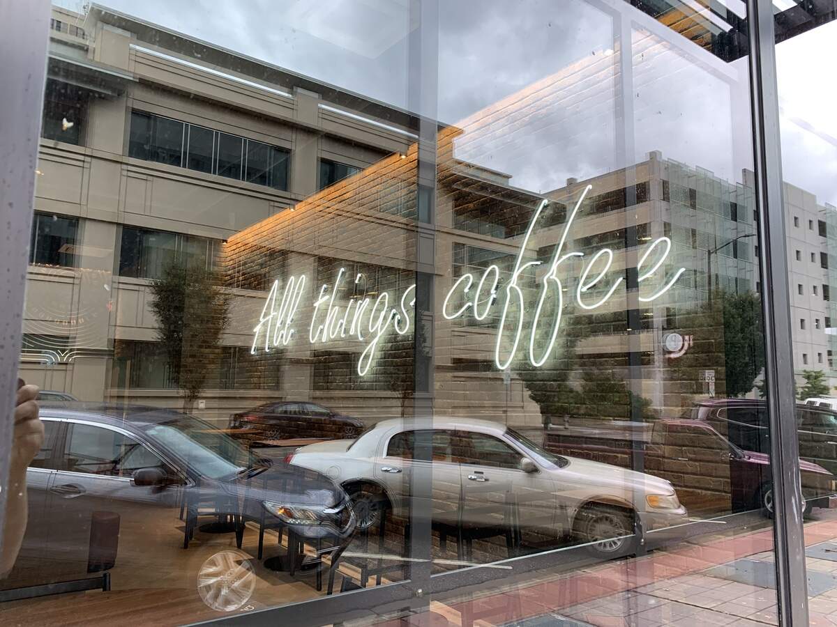 A neon sign hanging inside the new downtown Starbucks in Wichita reads “All Things Coffee.”