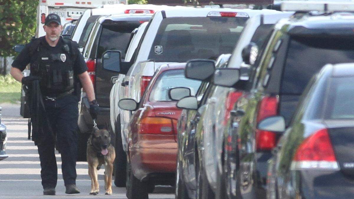 A Wichita police officer and K-9 walk back to their vehicle after a SWAT standoff ended Thursday in south Wichita when the suspect was taken down by a K-9.