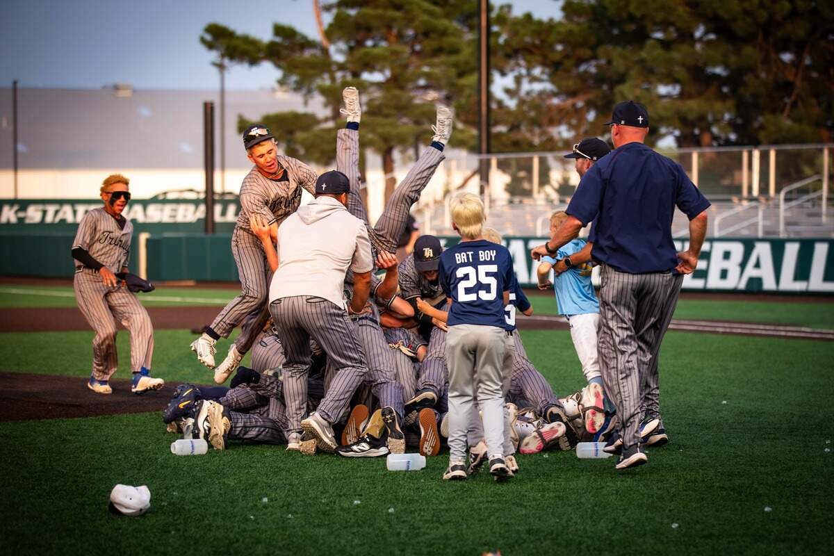 The Wichita Trinity Academy baseball team celebrates winning the Class 3A championship with a dog pile on the field.