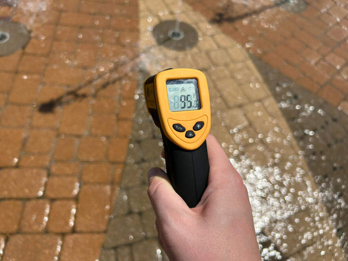 The wet ground of the splash pad at Riverside Park in Wichita measures 95 degrees Tuesday afternoon.