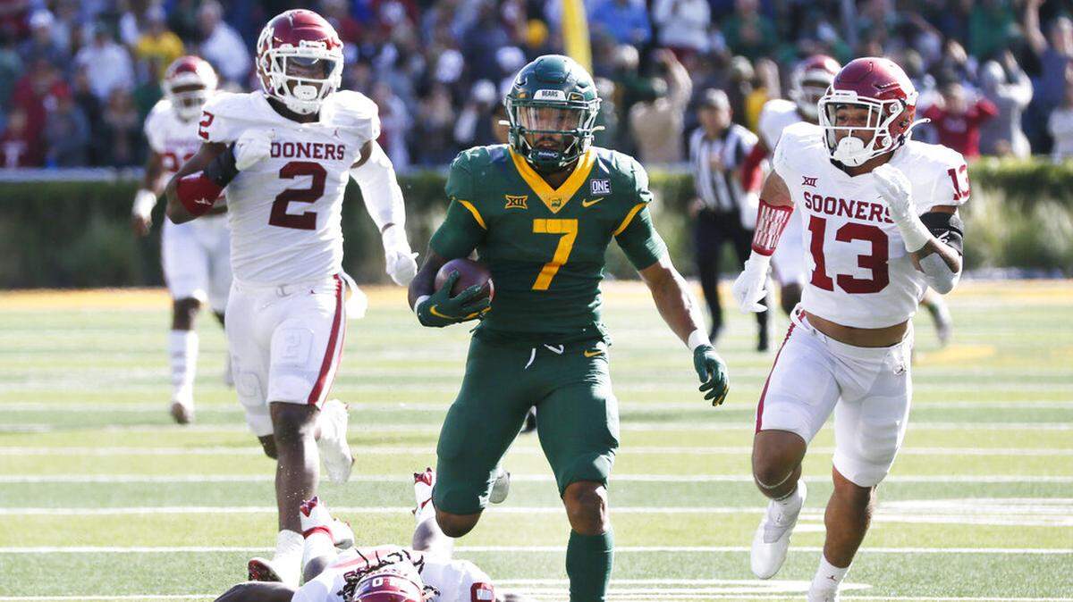 Baylor running back Abram Smith (7) breaks free on a 75-yard run as he is chased by Oklahoma linebacker David Ugwoegbu (2), safety Pat Fields (10) and linebacker Shane Whitter (13) during the second half of an NCAA college football game in Waco, Texas, Saturday, Nov. 13, 2021. (AP Photo/Ray Carlin)