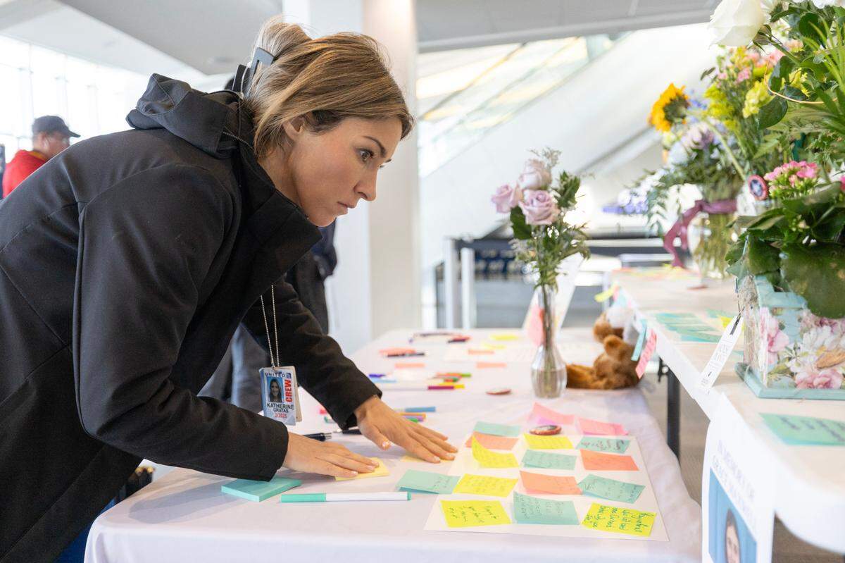 Katherine Gratas, a United Airlines flight attendant, leaves a message of condolence at a table set up for that purpose at Wichita’s Eisenhower Airport on Friday.