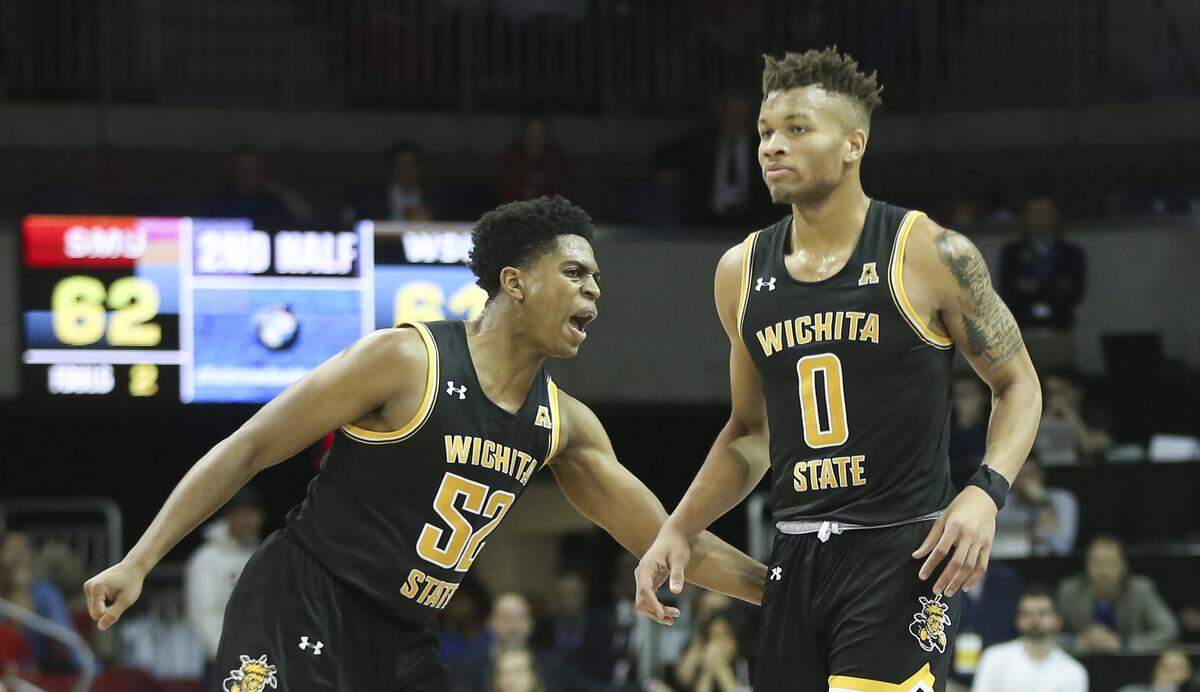 Dexter Dennis is congratulated by teammate Grant Sherfield after Dennis hit a three-pointer to complete a dramatic comeback after being down 24 to SMU in the second half. Wichita State went on to win 66-62.