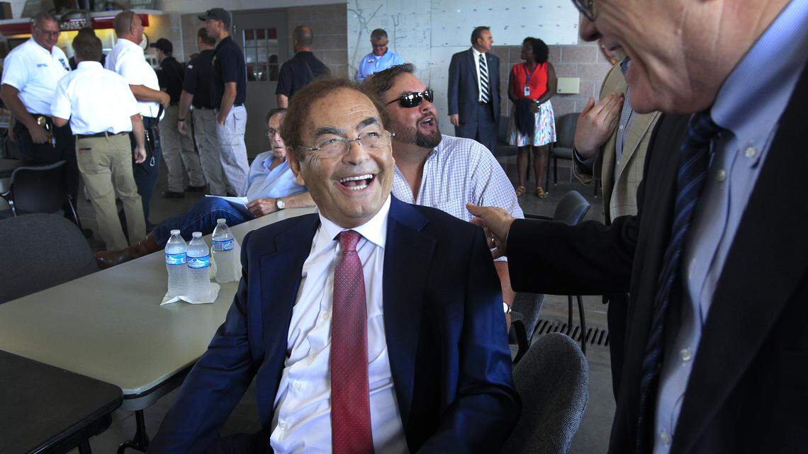 Phil Ruffin, center, receives congratulations from Sedgwick County Commissioner Dave Unruh, right, after buying the land where his Greyhound Park sits from the county at an auction at Fire Station 32 in Park City on Tuesday, July 17, 2018.