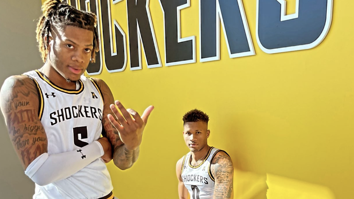 Wichita State basketball players Monzy Jackson (left) and Dexter Dennis (right) show off the team’s new home uniforms for this upcoming season.