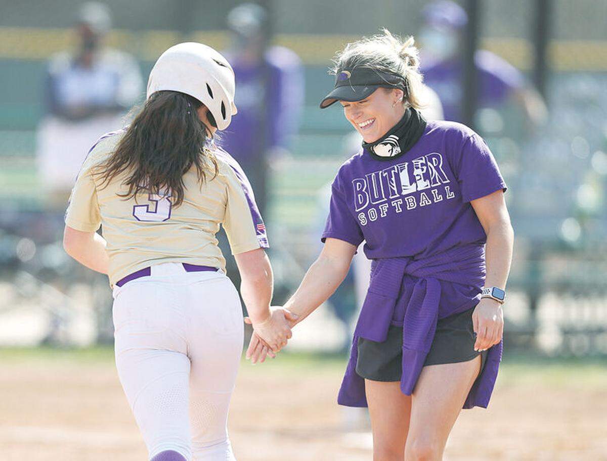 Madi Young (left) and her older sister Kenzie (right), who is now an assistant coach for Butler, share a moment following a home run by Madi.