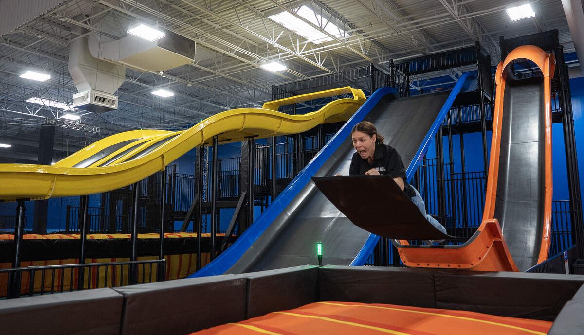 Sky Zone of Wichita co-owner Ashley Youngdale demonstrates a slide that catapults the rider onto a giant cushion.
