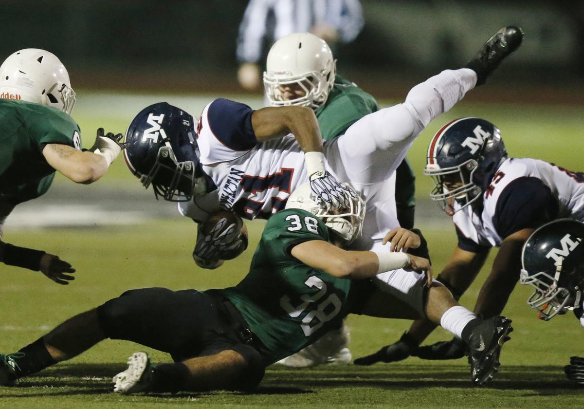 Manhattan running back #21 Kevontae McDonald is brought down by Derby defender #38 Jacob Ormsby.  (November 16, 2018)
