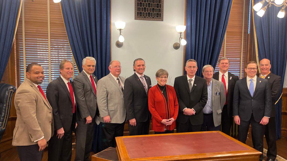 Gov. Laura Kelly, members of her administration and state legislators pose for pictures after announcing $304 million subsidy deal for semiconductor plant.
