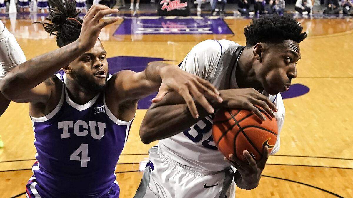 TCU center Eddie Lampkin Jr. (4) tries to steal the ball from Kansas State forward Nae’Qwan Tomlin (35) during the first half of an NCAA college basketball game Tuesday, Feb. 7, 2023, in Manhattan, Kan. (AP Photo/Charlie Riedel)