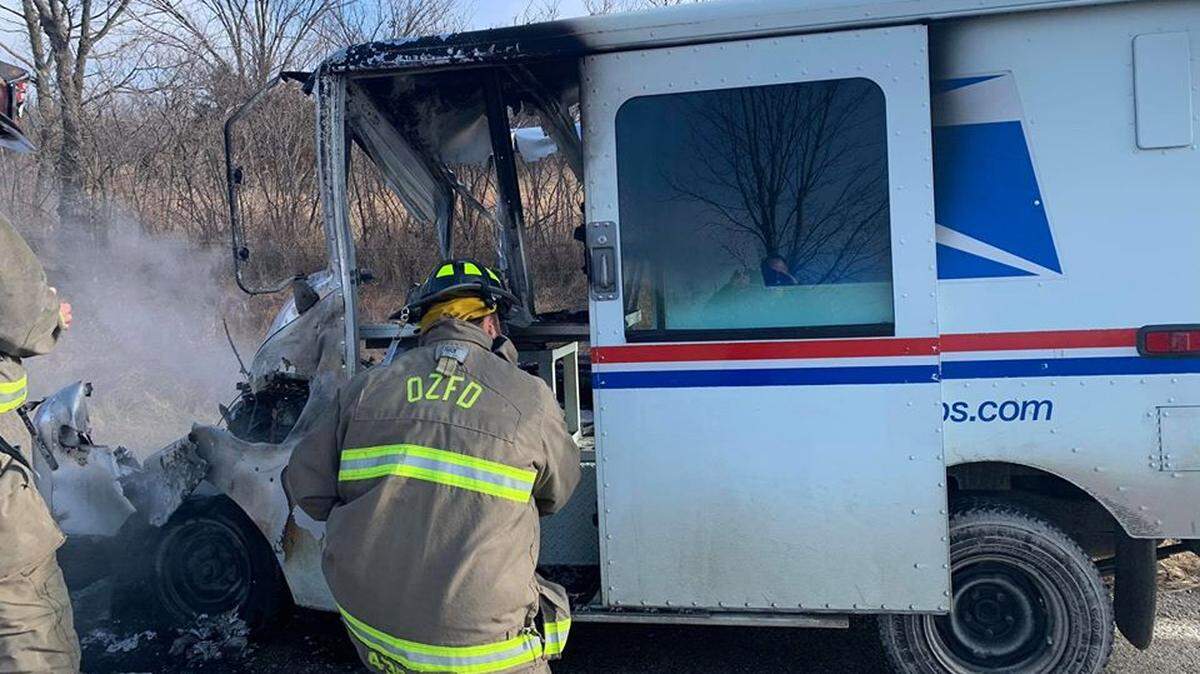 Firefighters put out a fire on a mail truck.