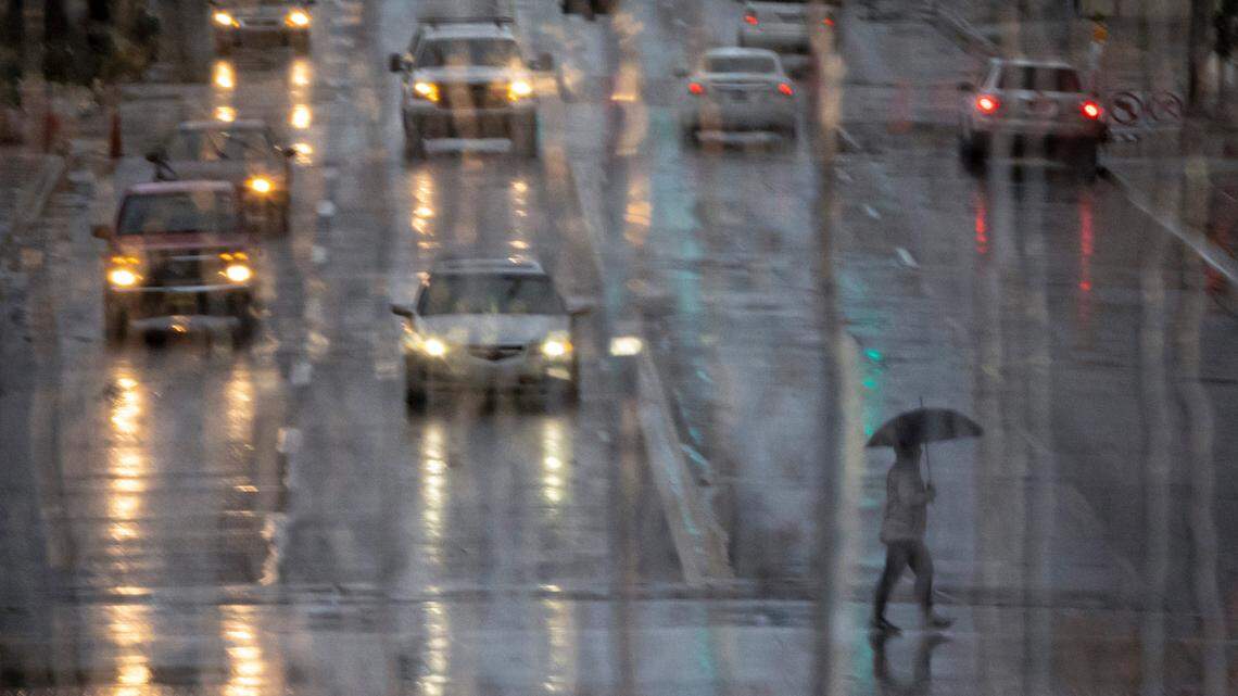 A pedestrian crosses Broadway at Douglas in the rain in this file photo. Here are the latest rainfall totals from the National Weather Service following Tuesday night’s storm in Sedgwick County.