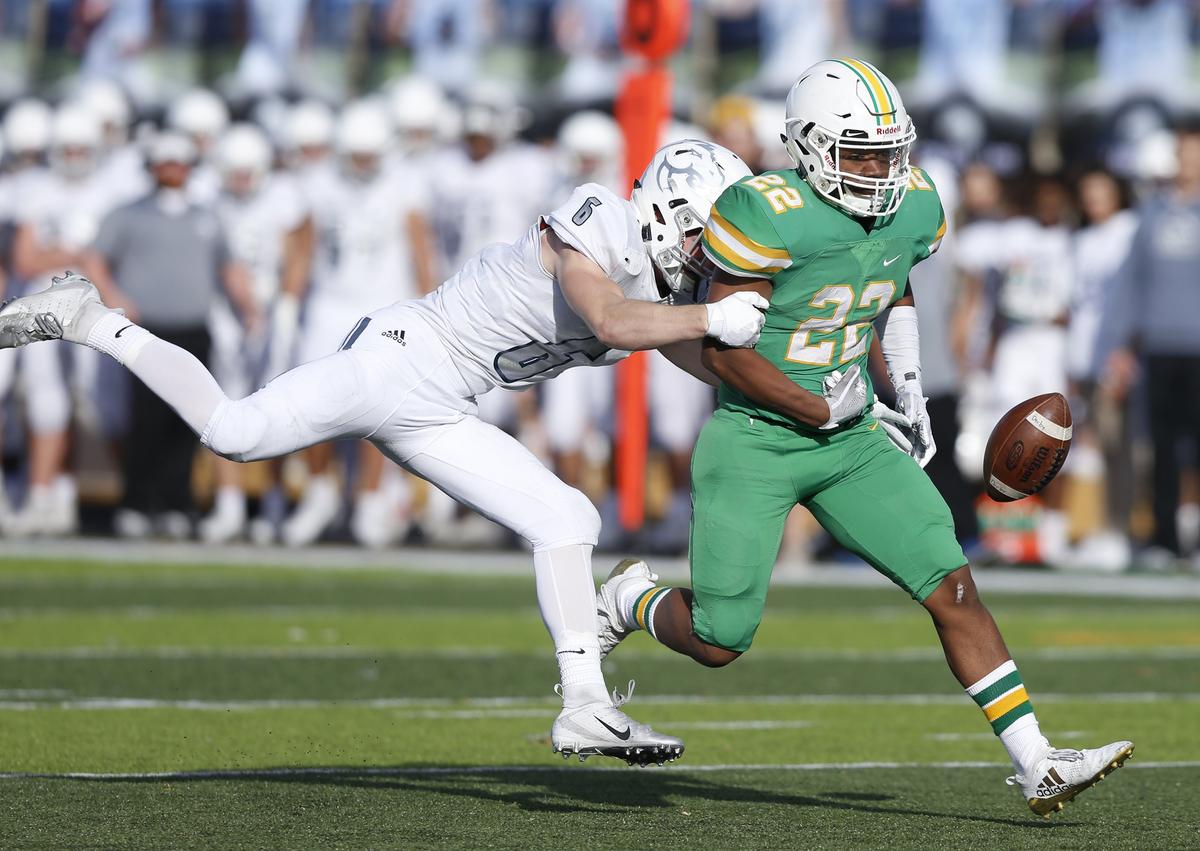 Blue Valley North linebacker #6 Nicholas Detmer  knocks the ball away from Derby running back Tre Washington.  Blue Valley North recovered the fumble.  (November 24, 2018)