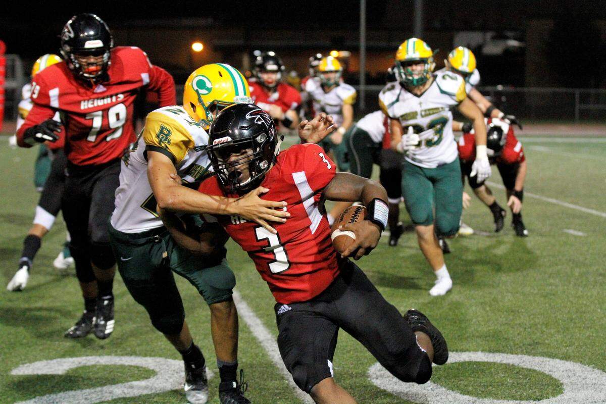 K’Vonte Baker, Wichita Heights senior quarterback, tries to evade Phoenix Smith, a Bishop Carroll junior defensive end, in the Golden Eagles’ 36-20 win over the Falcons on Friday. (Sept. 7, 2018)
