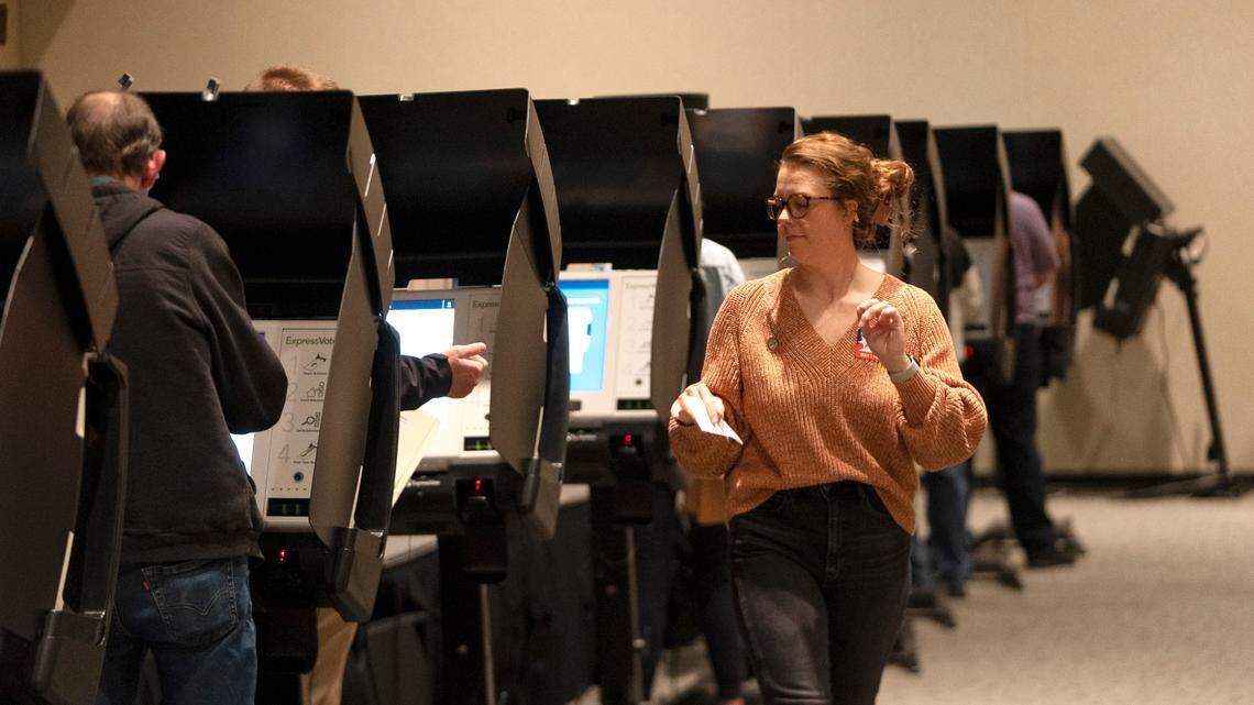 A poll worker walks past voters at Grace Presbyterian during the Kansas midterm election.