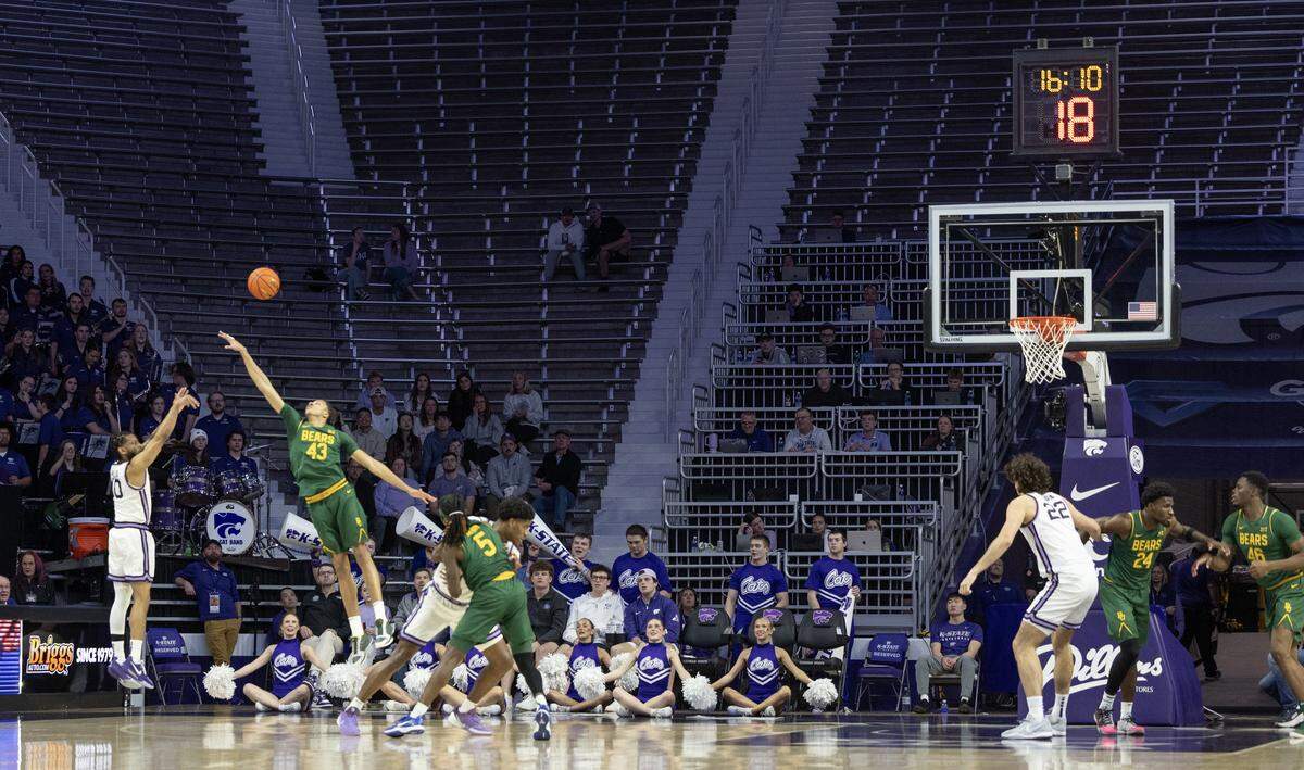 Kansas State’s David Castillo shoots a three pointers against Baylor’s Cameron Carr before a sparse crowd at Bramlage Coliseum on Tuesday night. Head coach Jerome Tang was fired just a few days prior.