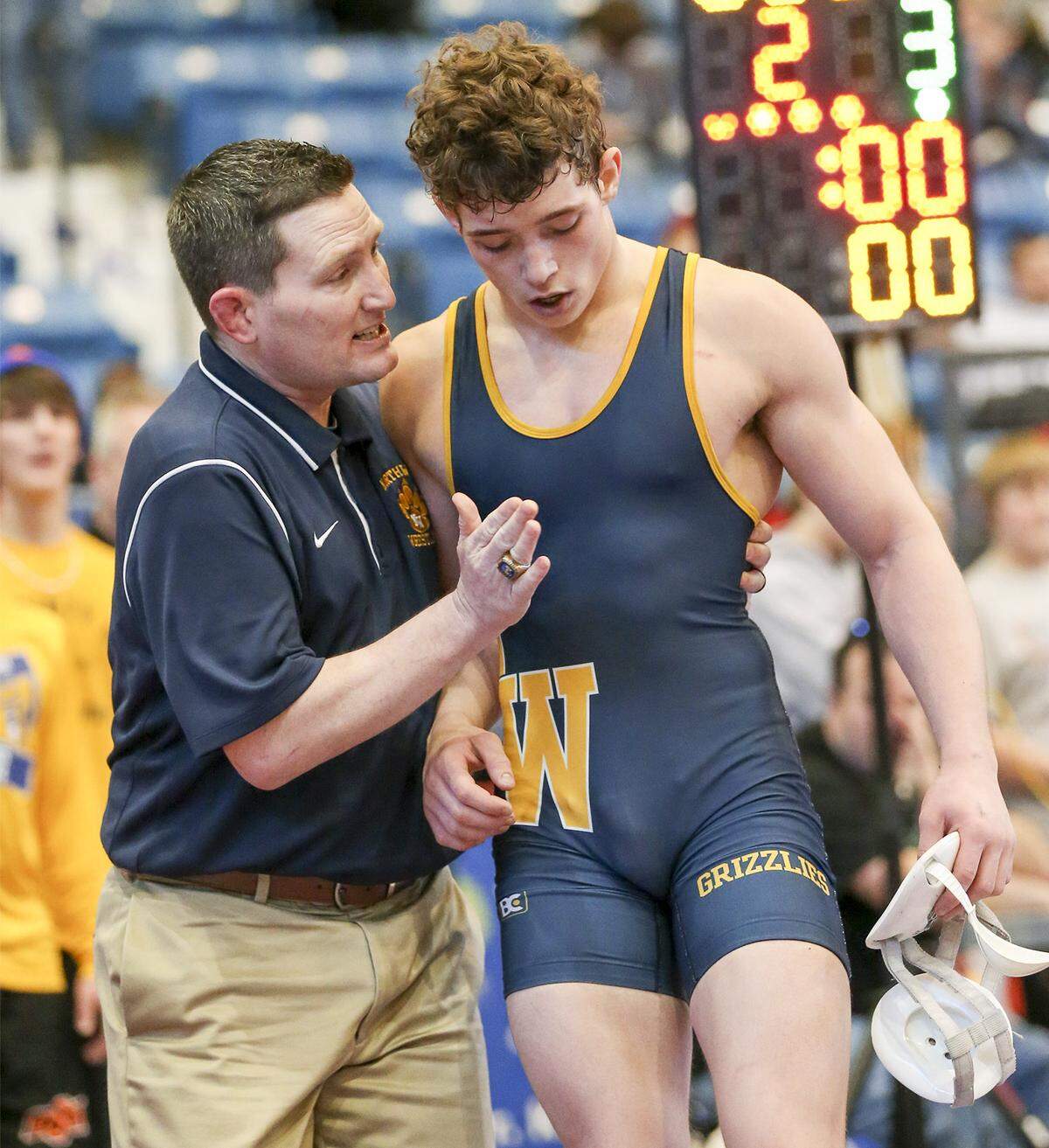 Northwest coach Eric Prichard, left, congratulates his wrestler Dylan Beckner after his victory in the 6A-145 lb. semifinal at the State Wrestling Championships at Hartman Arena Friday. (Feb. 28, 2014)