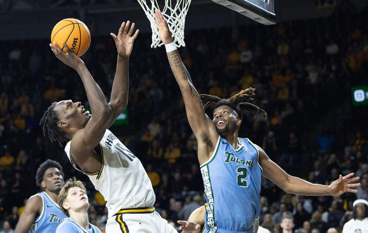 Wichita State’s goes up for a shot against Tulane’s AGregg Glenn III during the second half of their game on Sunday at Koch Arena.