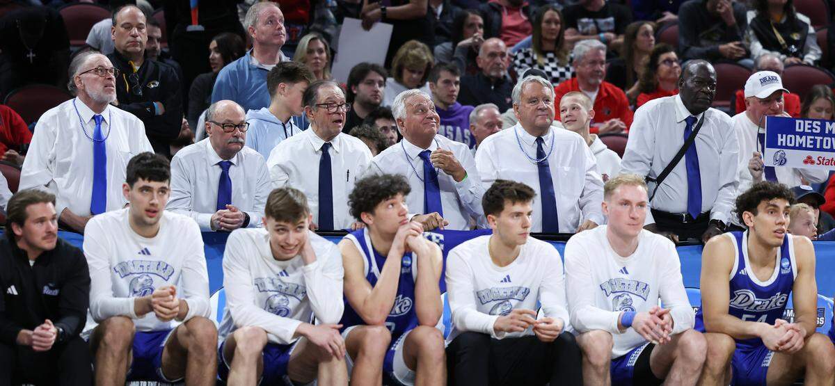 Fans dressed up like Drake head coach Ben McCollum stand behind the bench during the second half of their NCAA Tournament game in Wichita on Thursday, March 20, 2025.