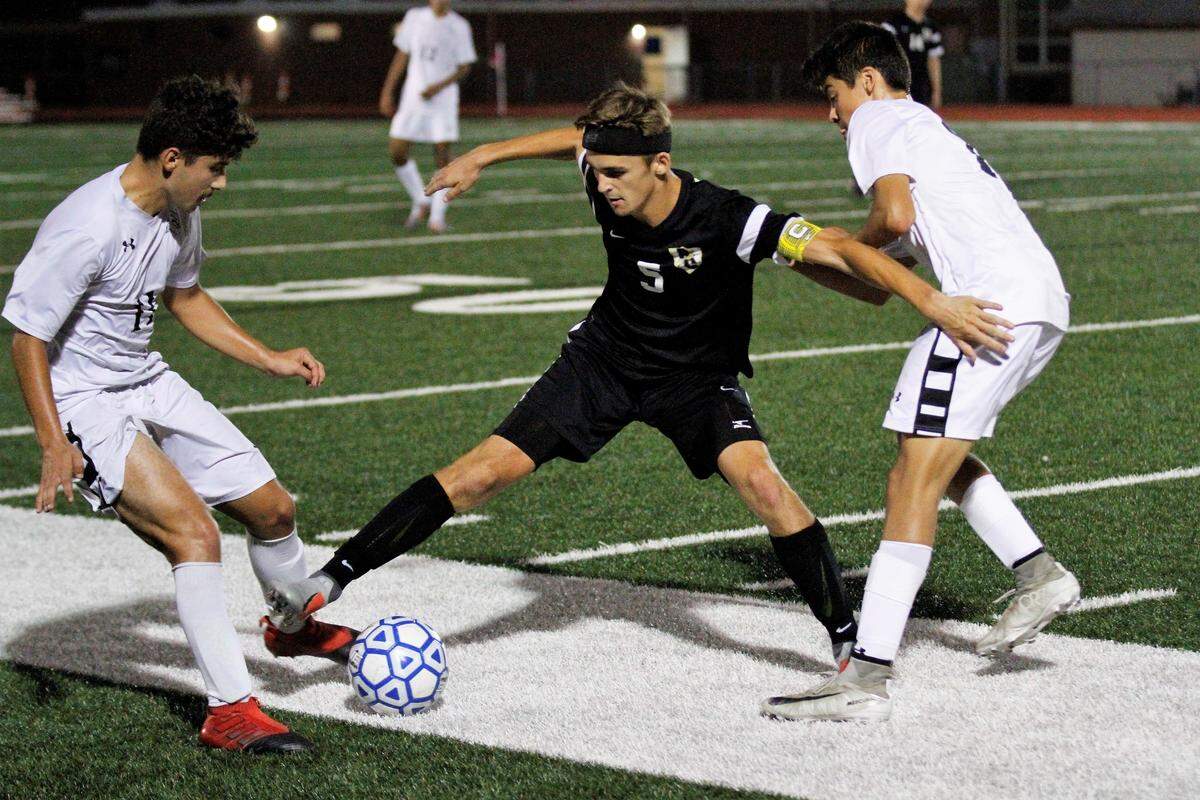 Andover Central captain Max Wurth holds off a couple of Campus players in the Jaguars’ 1-0 win over the Colts on Tuesday. (Sept. 11, 2018)