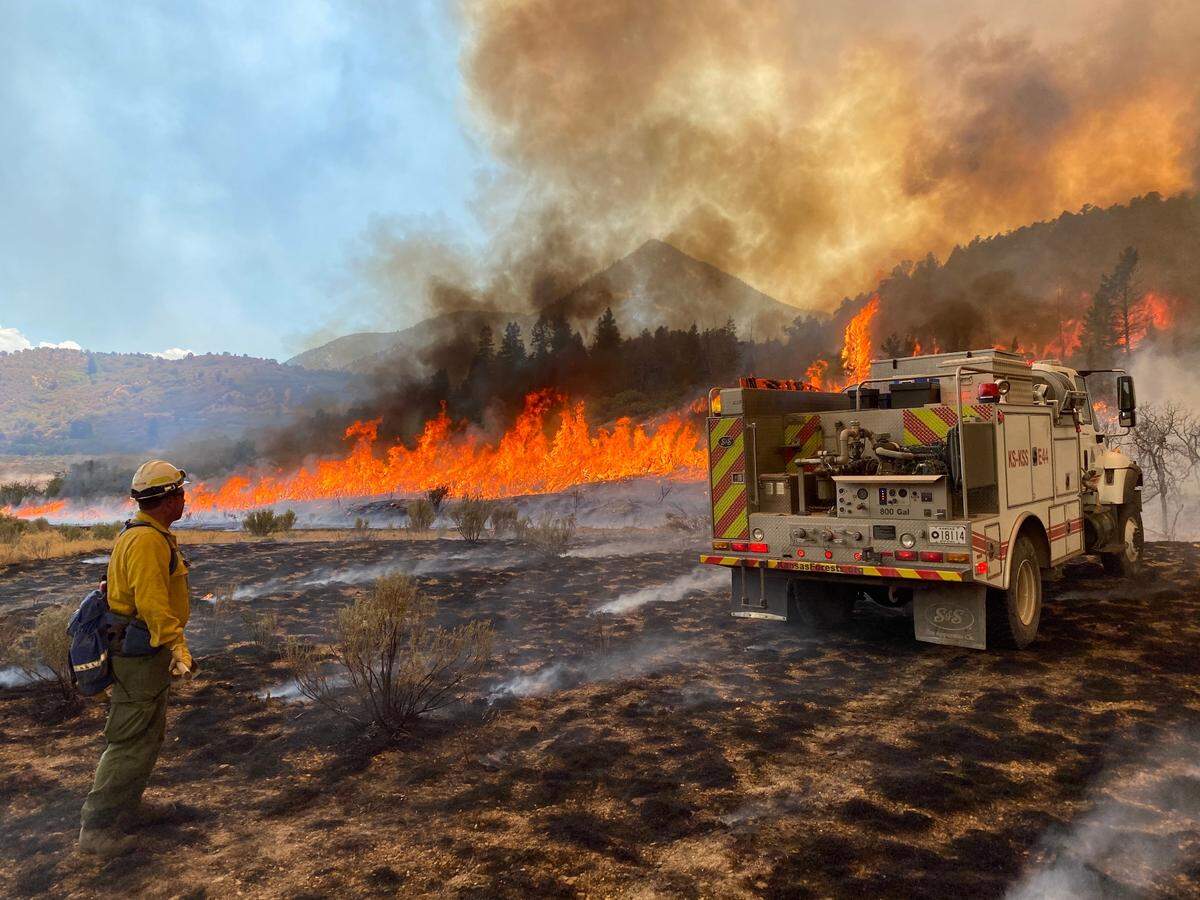 David Brunton, a Kansas Forest Service marketing forester, watches a fire near Engine 44 at the Pine Gulch Fire. The Pine Gulch Fire is the largest wildfire in Colorado history, burning 139,000 acres last July through September.
