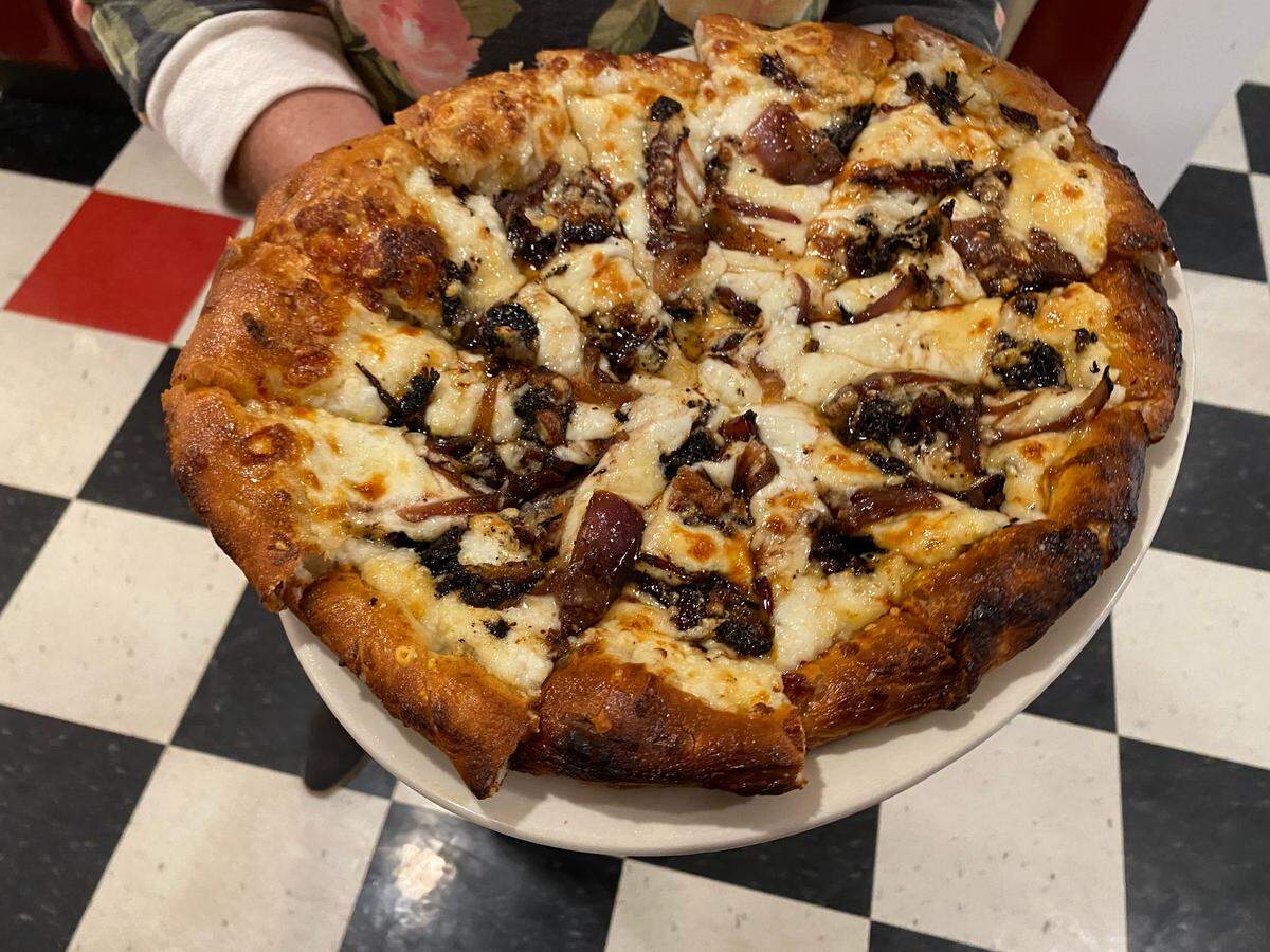 The smothered breakfast burrito pizza at Doo-Dah diner features chorizo, green chili, jalapenos and more.