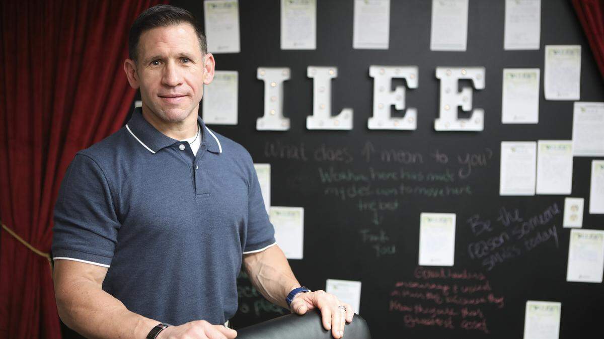 Chance Cortez Becnel, President of Axiom Healthcare Services stands in front of the company’s slogan ILEE, which stands for Improving Lives, Exceeding Expectations. (May 7, 2019)