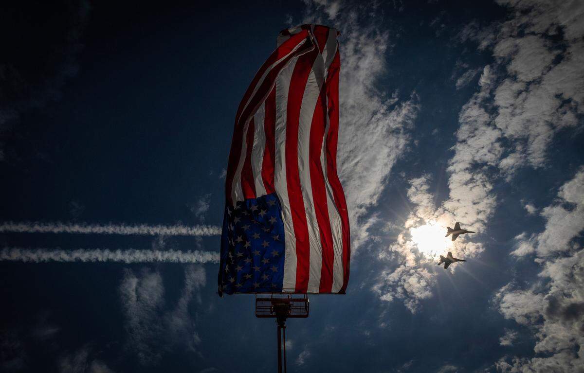 Two members of the Blue Angels soar over a flag positioned in the center of the McConnell airfield on Saturday during the Frontiers in Flight airshow.