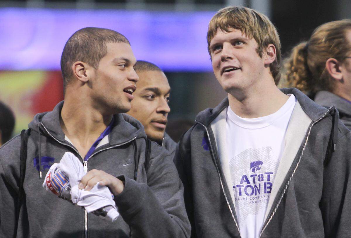 Kansas State Tysyn Hartman, left and Collin Klein look at the crowd during a pep rally at the Ballpark at Arlington on Thursday night. (Jan. 5, 2012)