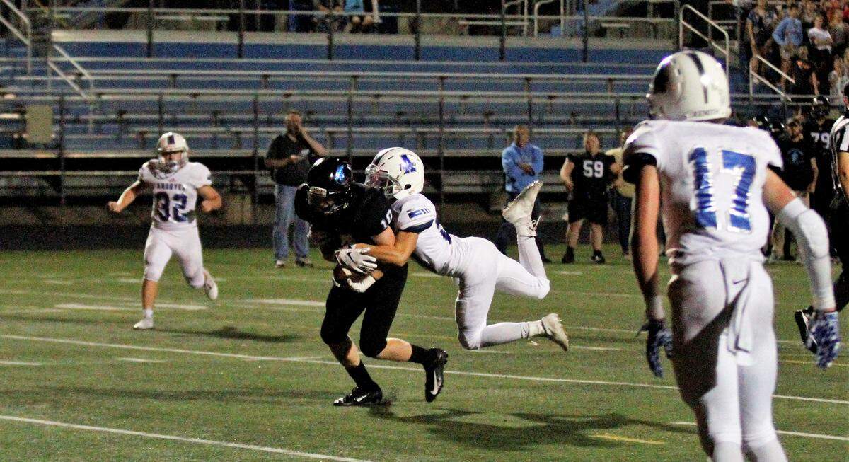 Goddard Eisenhower sophomore receiver Cody Houser hauls an Andover defender into the end zone during the Tigers’ 30-22 loss to the Trojans on Thursday night. (Sept. 13, 2018)