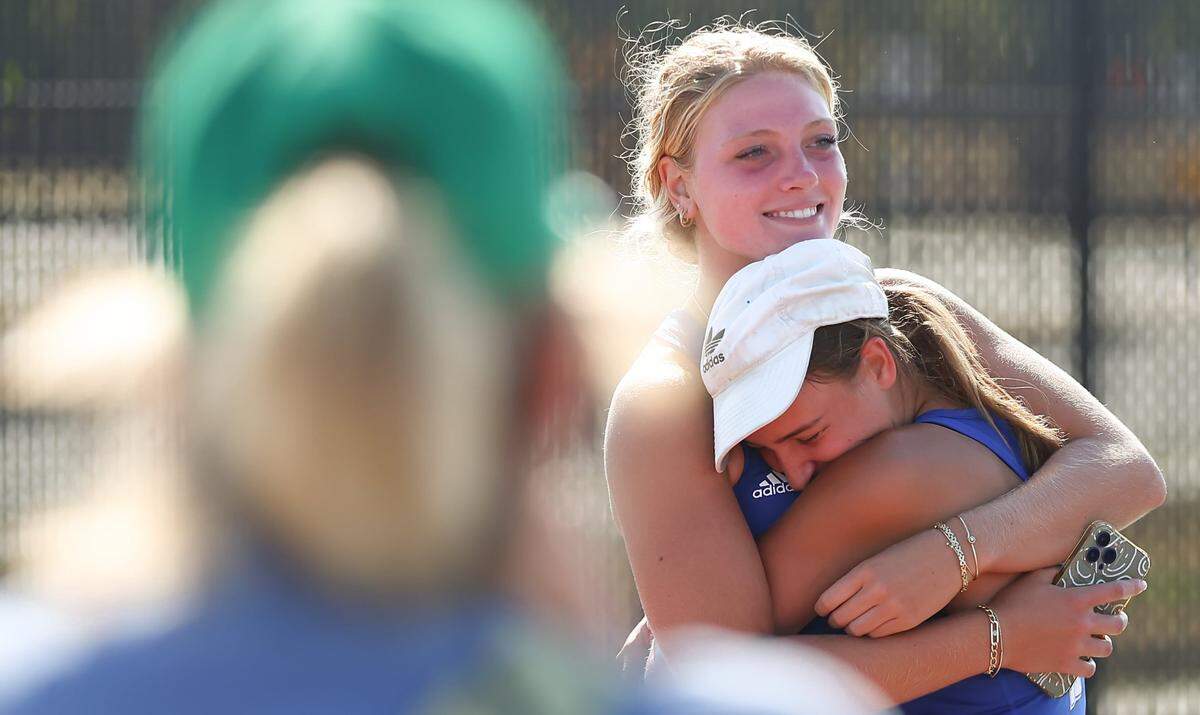 Molly Gaddis and her twin sister, Elizabeth, embrace in a hug with their mother, Jenny, watching after both won a state championship at the Class 5A state tournament in Andover this past Saturday.