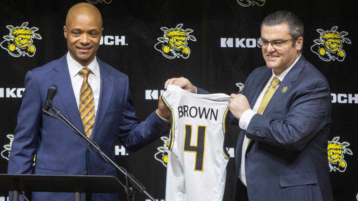 Wichita State athletic director Darron Boatright, right, and new men’s basketball coach Isaac Brown hold up a jersey with Brown’s name on it after Brown was officially introduced as the new men’s basketball coach at Wichita State on Monday.