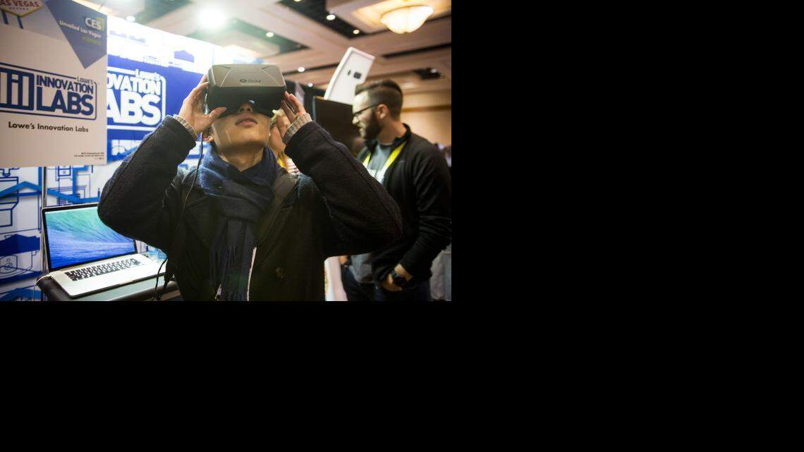 
A guest uses an Oculus VR Inc. virtual reality headset at the Lowe's Innovation Labs stall during the CES Unveiled press event ahead of the 2015 Consumer Electronics Show in Las Vegas, Nevada, U.S., on Sunday, Jan. 4, 2015. This year's CES will be packed with a wide array of gadgets such as drones, connected cars, a range of smart home technology designed to make everyday life more convenient and quantum dot televisions, which promise better color and lower electricity use in giant screens. 
