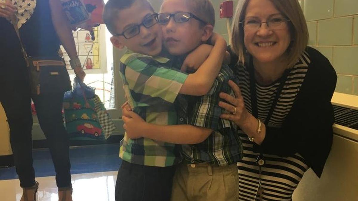 Best friends Christian Londono Cox, left, and Elijah Bucinski share a hug on the last day of kindergarten with their teacher, Cindy Deutsch.