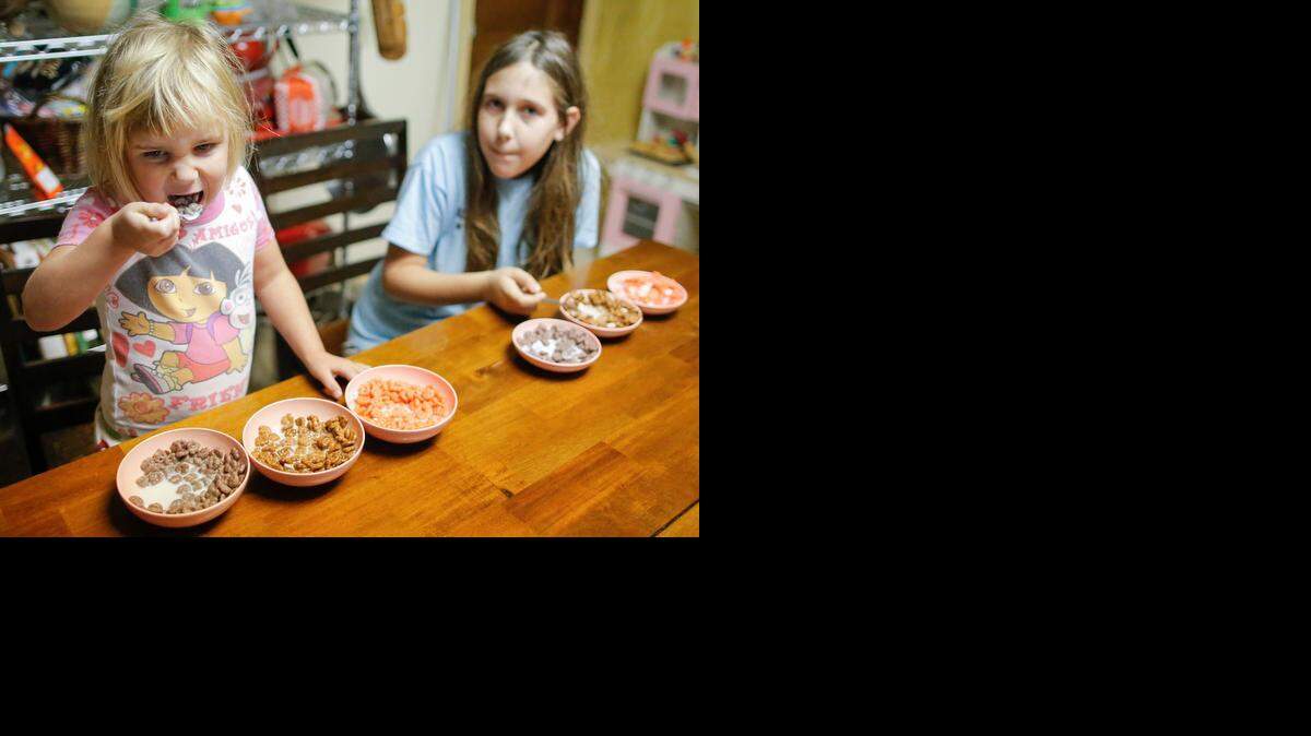 
Helen, 4, and Lexi, 9, perform a Saturday-morning taste test on General Mills’ three sugary Halloween cereals.
