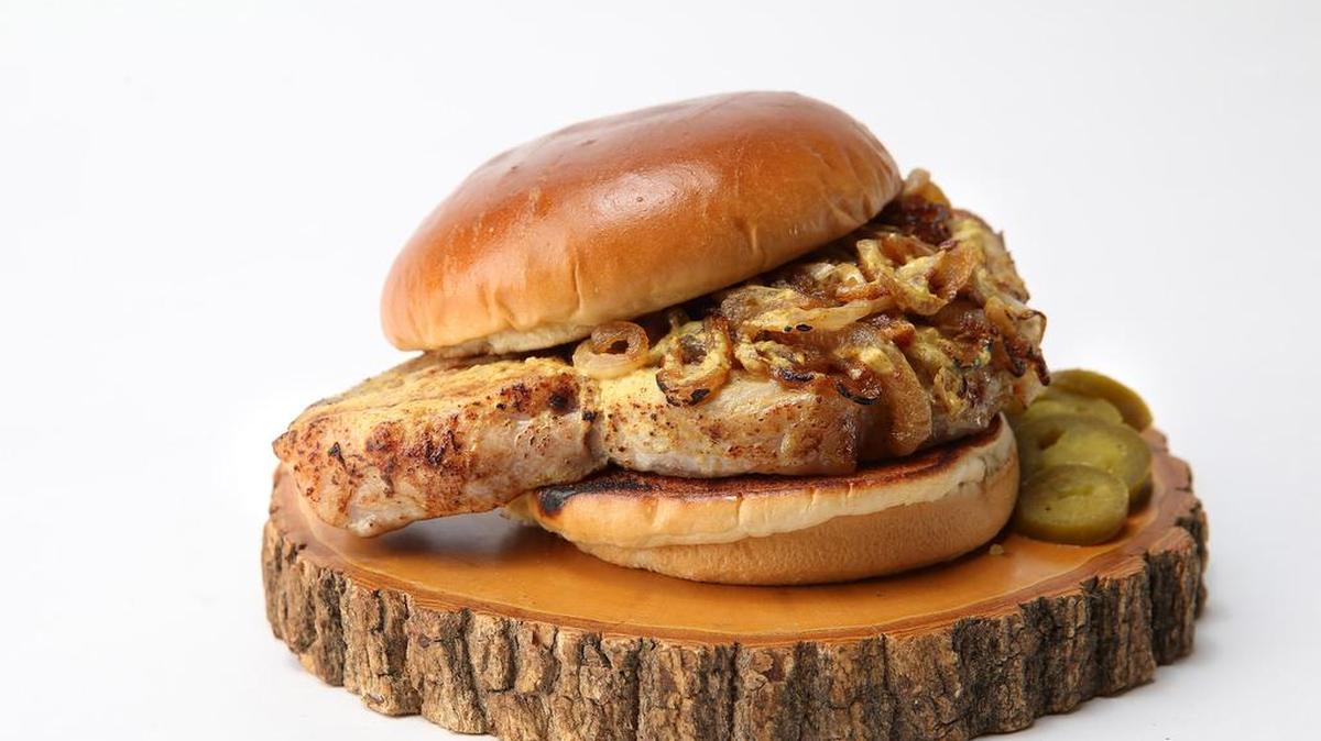 The Maxwell Street Market sandwich features a grilled pork chop topped with mustard-spiked caramelized onions.