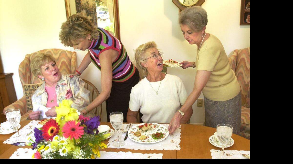 
Nancy Brammer, right, hostess of May’s gathering of the Thursday Afternoon Cooking Club, serves Ann McBride as Elizabeth Enoch serves Marilyn Wells. The club has been meeting since the late 1800s. They meet once a month when a different hostess serves lunch and shares the recipes with its members. (2003)
