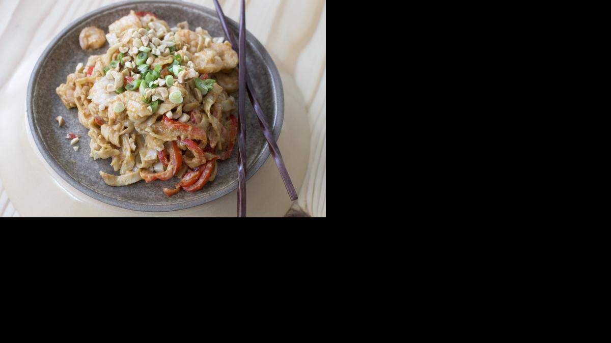 
 Fried udon noodles with red peppers and shrimp, all slathered in a spicy peanut sauce is simple and filling. 
