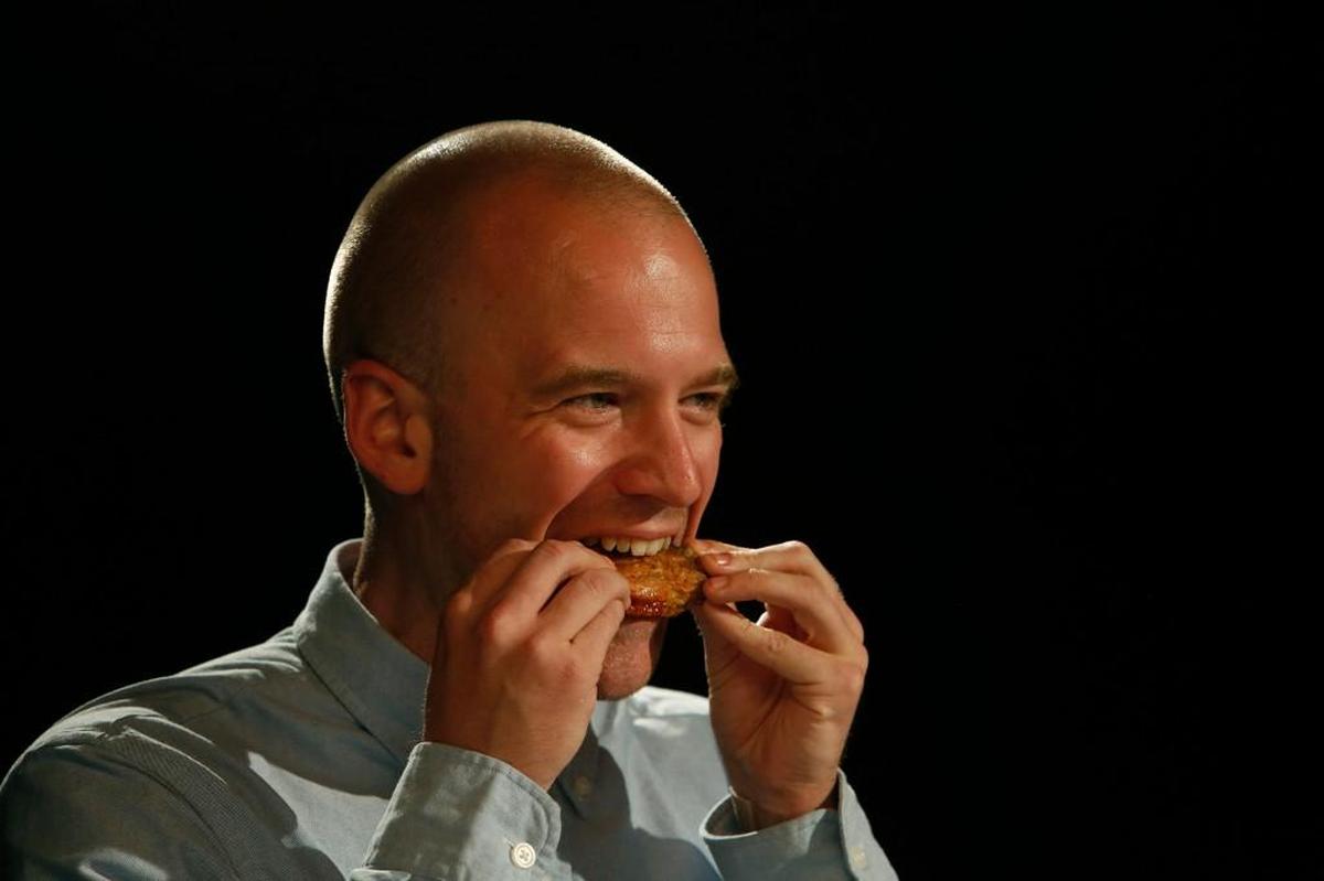 Sean Evans, host of YouTube’s “Hot Ones,” bites into a chicken wing as he interviews comedian Bert Kreischer during a show. Evans returns to Big Slick this year.
