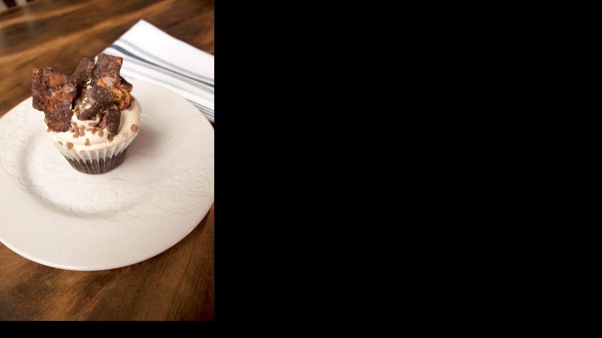 
A Cheez-Its Cupcake is served at Little Goat Bakery. It is a Cheez-Its cake with vanilla buttercream frosting and then chocolate covered Cheez-Its on top. 
