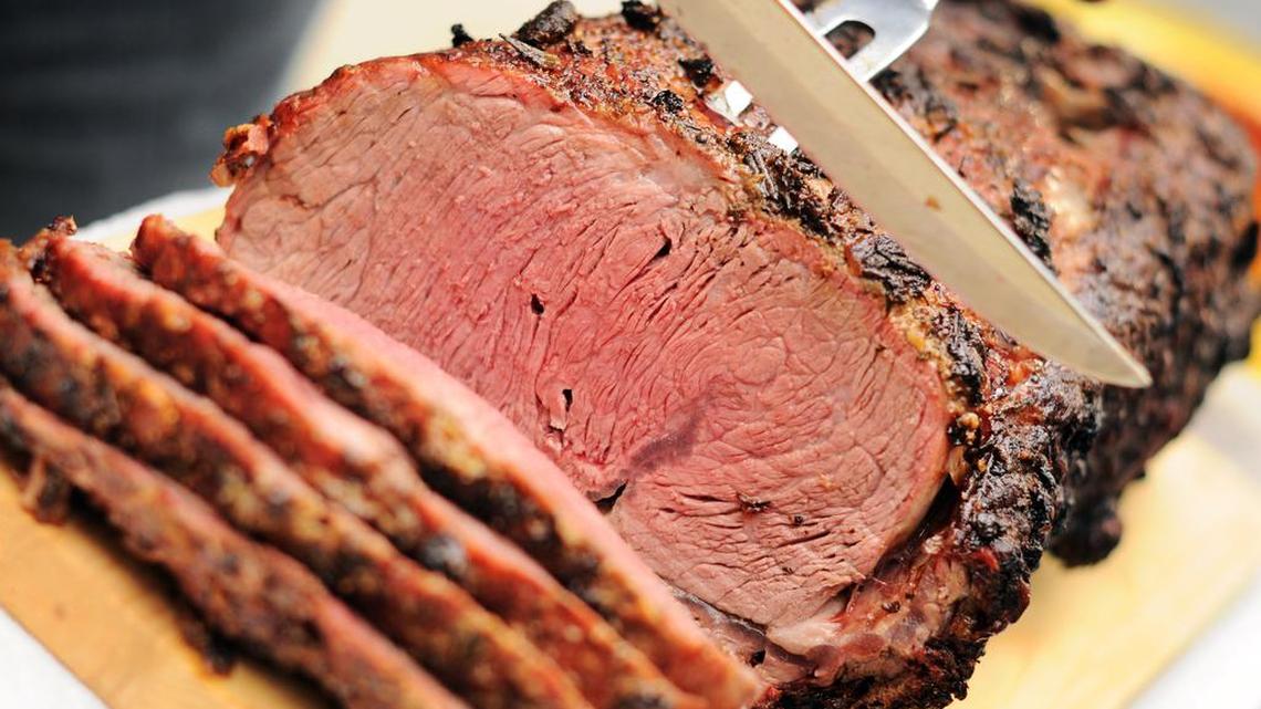 “Beautiful prime rib (standing rib) roast being sliced. Crusted with garlic, rosemary and horseradish. Cooked on a barbeque.”