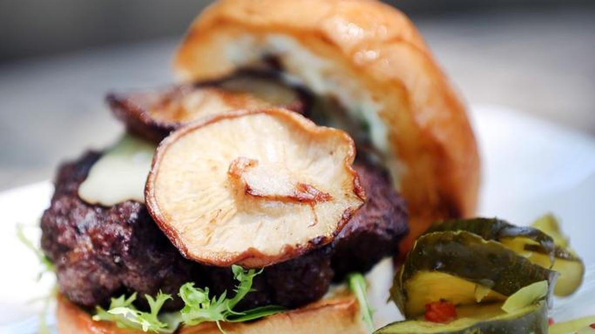 Burgers with grilled Shiitake mushrooms and Swiss cheese.